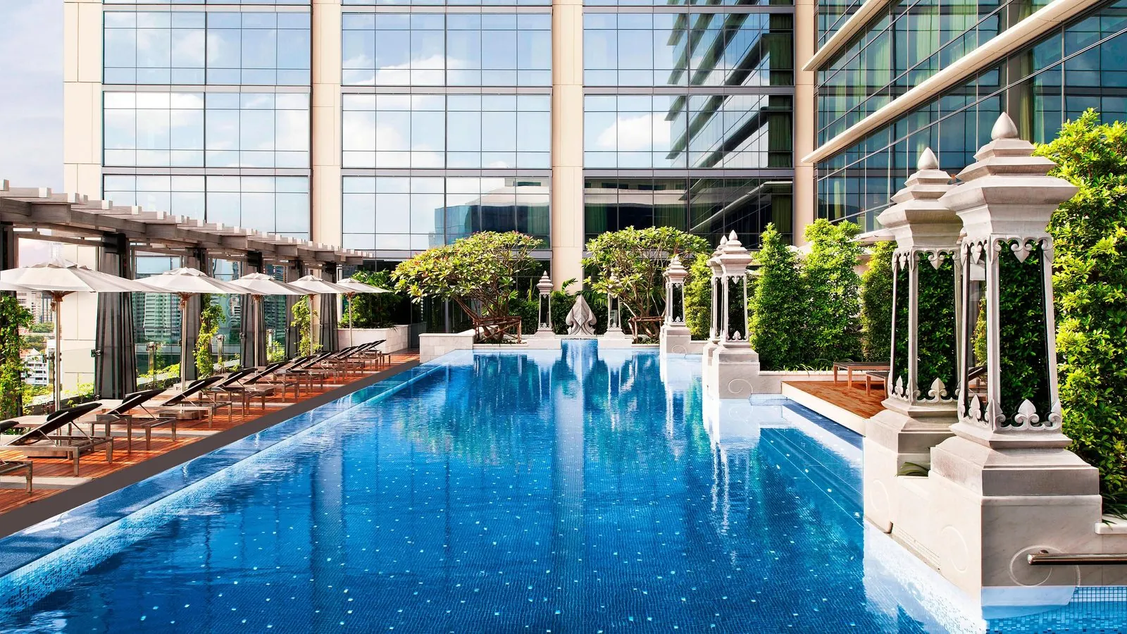 Outdoor pool with Thai-style pavilions and loungers at The St. Regis Bangkok