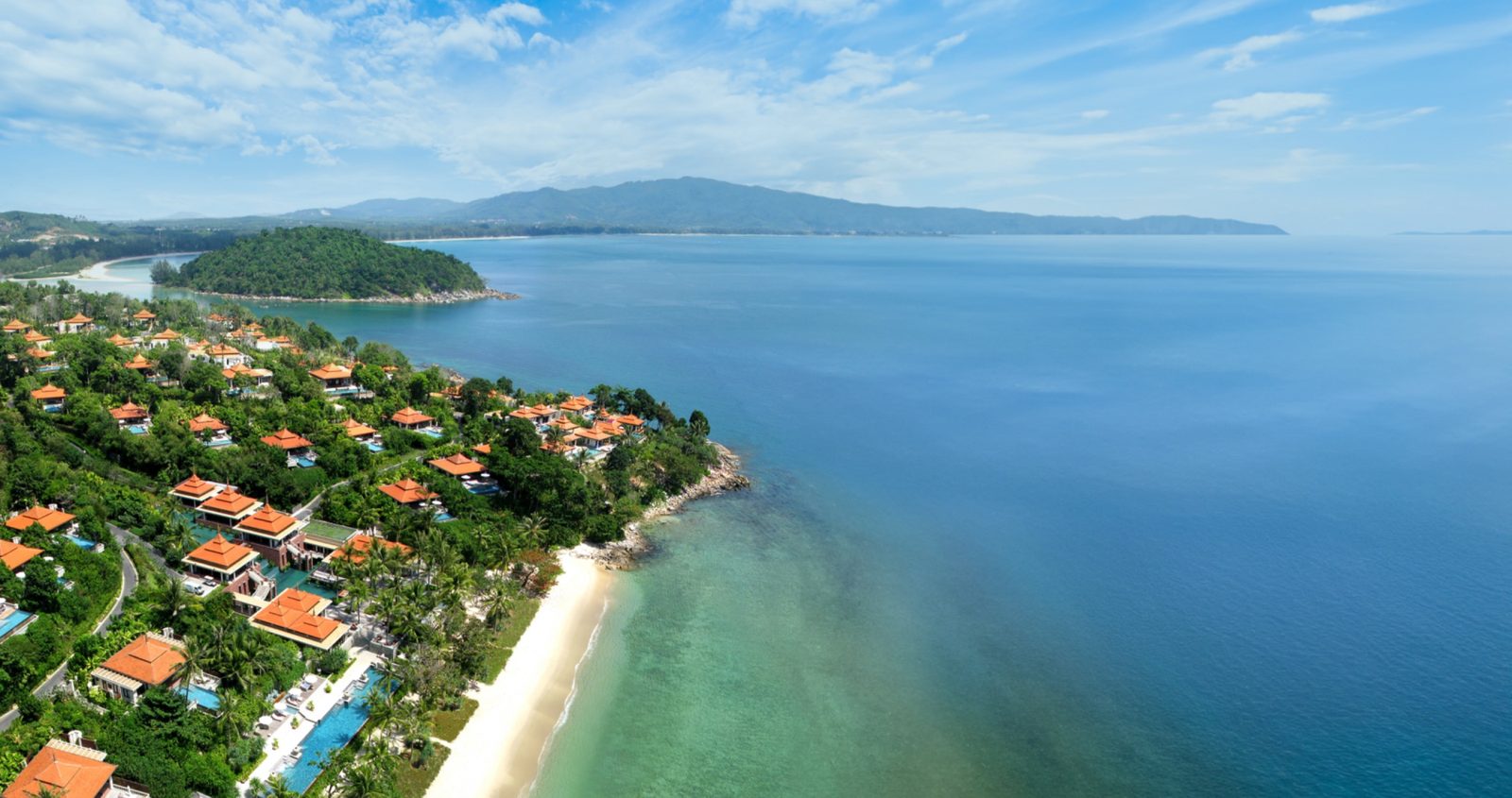 Aerial view of Trisara on Phuket's north-western coast, with villas among trees above the Andaman Sea