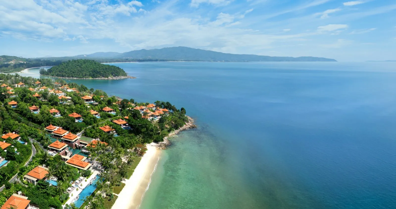 Aerial view of Trisara on Phuket's north-western coast, with villas among trees above the Andaman Sea