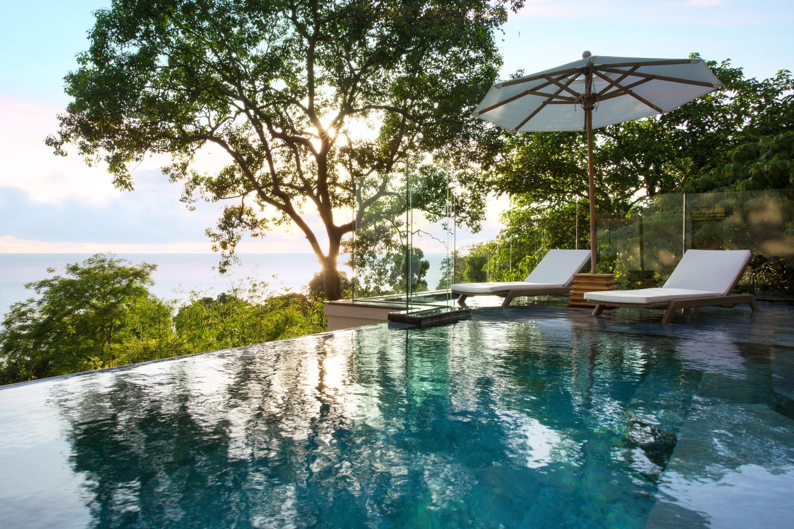 Pool and sun loungers of an Ocean View Pool Junior Suite at Trisara, facing the sea