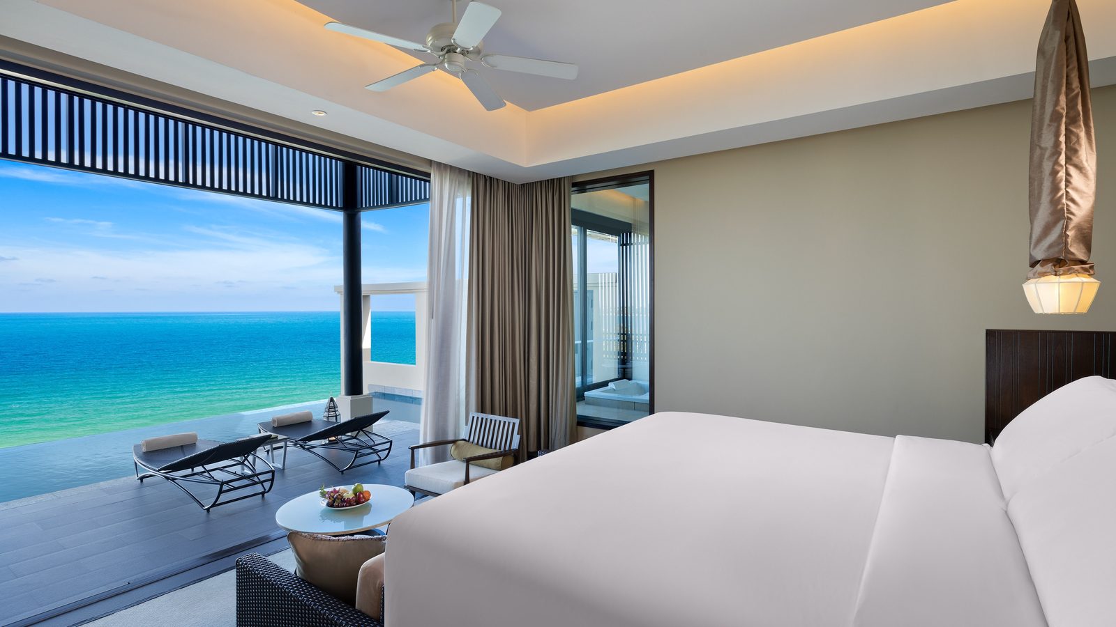 Grand Ocean View Pool Suite bedroom opening onto its terrace at Vana Belle