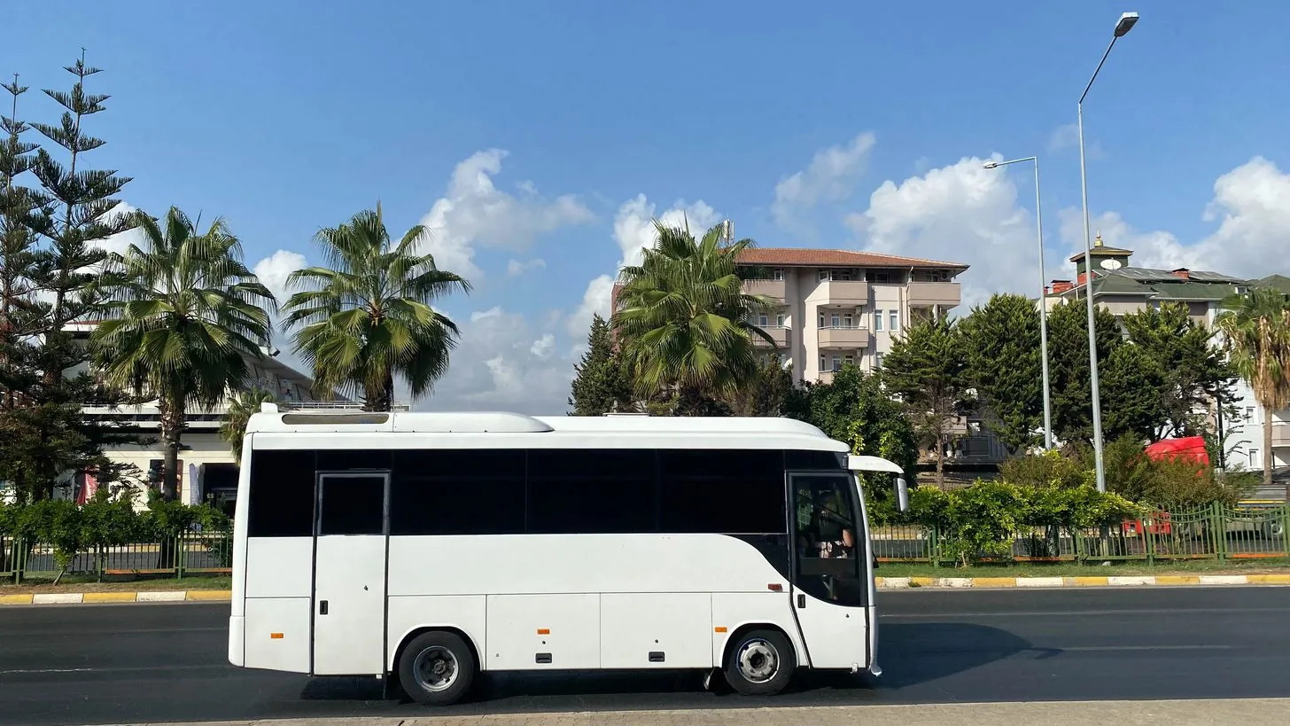 Modern coach on a palm-lined road in Thailand — Explera managed transport fleet