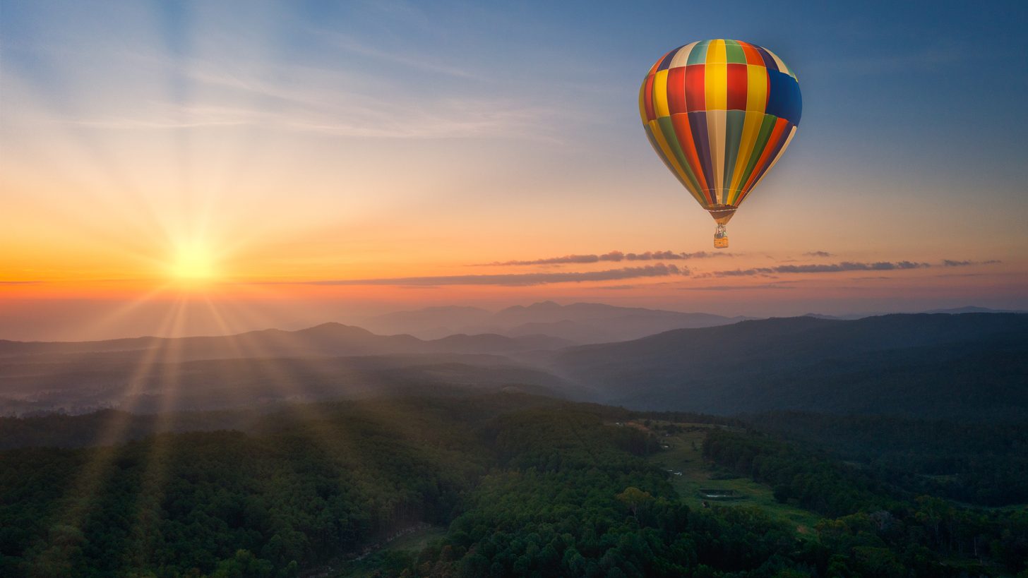 Hot-air balloon at sunrise over the mountains and pine forest of Chiang Mai province