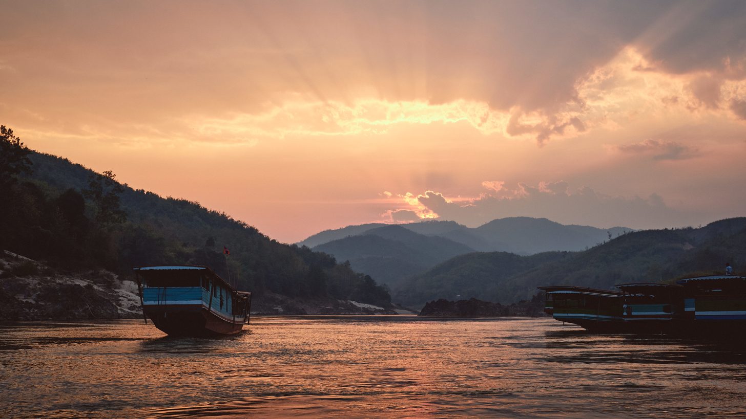 Wooden boats on the Mekong River in the Golden Triangle at sunset