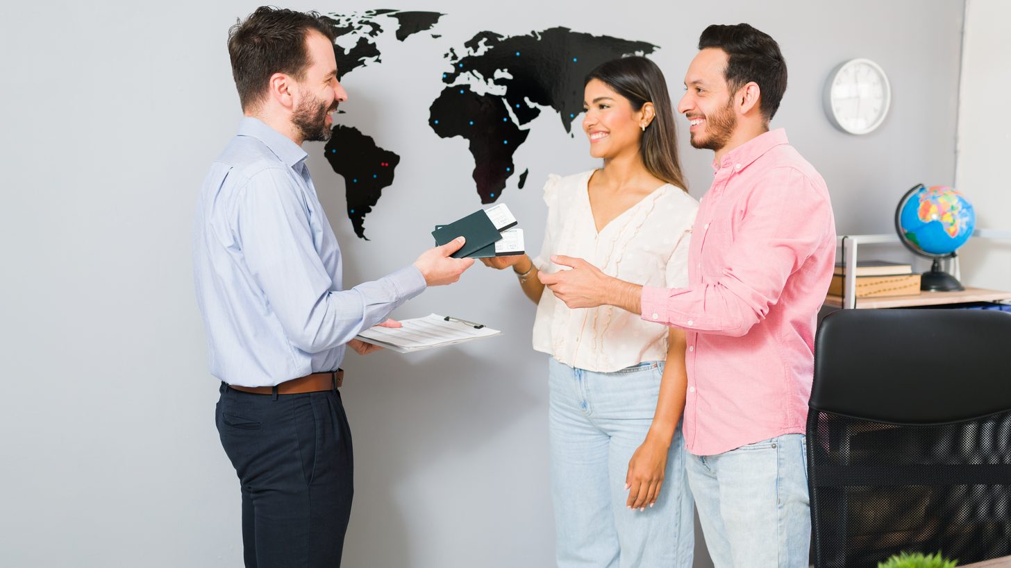 Travel agency handing clients their documents — the agency brand in front, the DMC running the ground